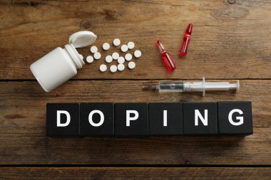 Kelime Doping ve uyuşturuculu siyah küpleri tahta arka planda, düz yatıyordu