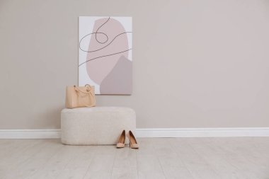 Poşetli şık bir pouf ve içeride bej duvarın yanında ayakkabılar. Metin için boşluk