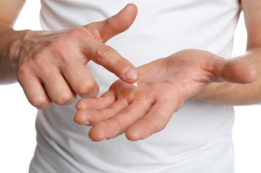 Man applying cream on hand for calluses treatment against white background, closeup clipart