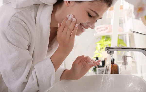 漂亮的少女在浴室里用洁白泡沫洗脸 护肤化妆品 — 图库照片
