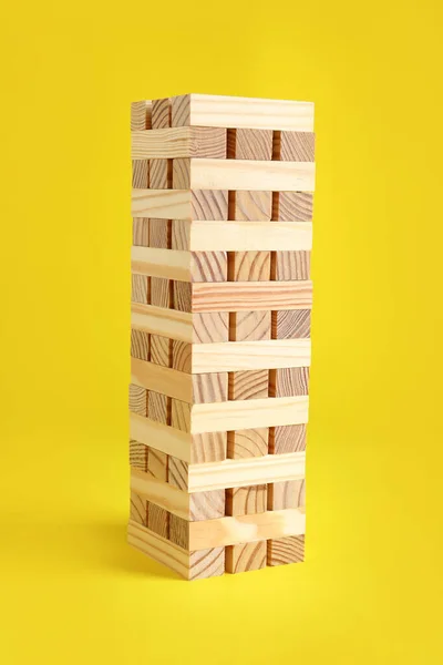 Jenga Toren Gemaakt Van Houten Blokken Gele Achtergrond — Stockfoto