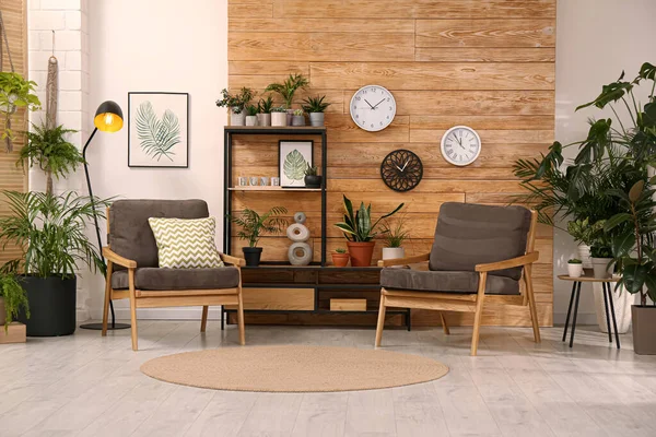 美しい緑の植物と快適な家具とスタイリッシュな部屋のインテリア — ストック写真