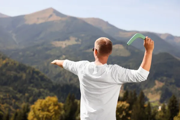 晴れた日に山の中でブーメランを投げる男 バックビュー — ストック写真
