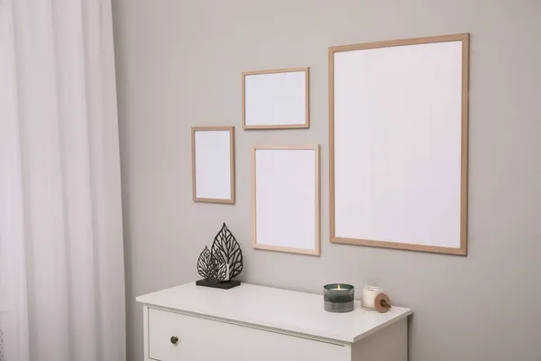 Lege Lijsten Hangend Aan Grijze Muur Boven Witte Ladekast Mockup — Stockfoto