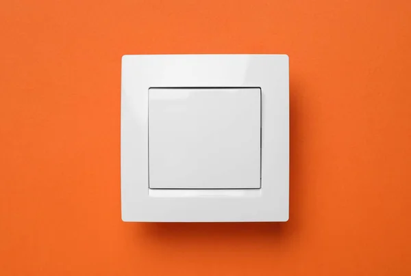 White Plastic Light Switch Orange Background — Stock Photo, Image