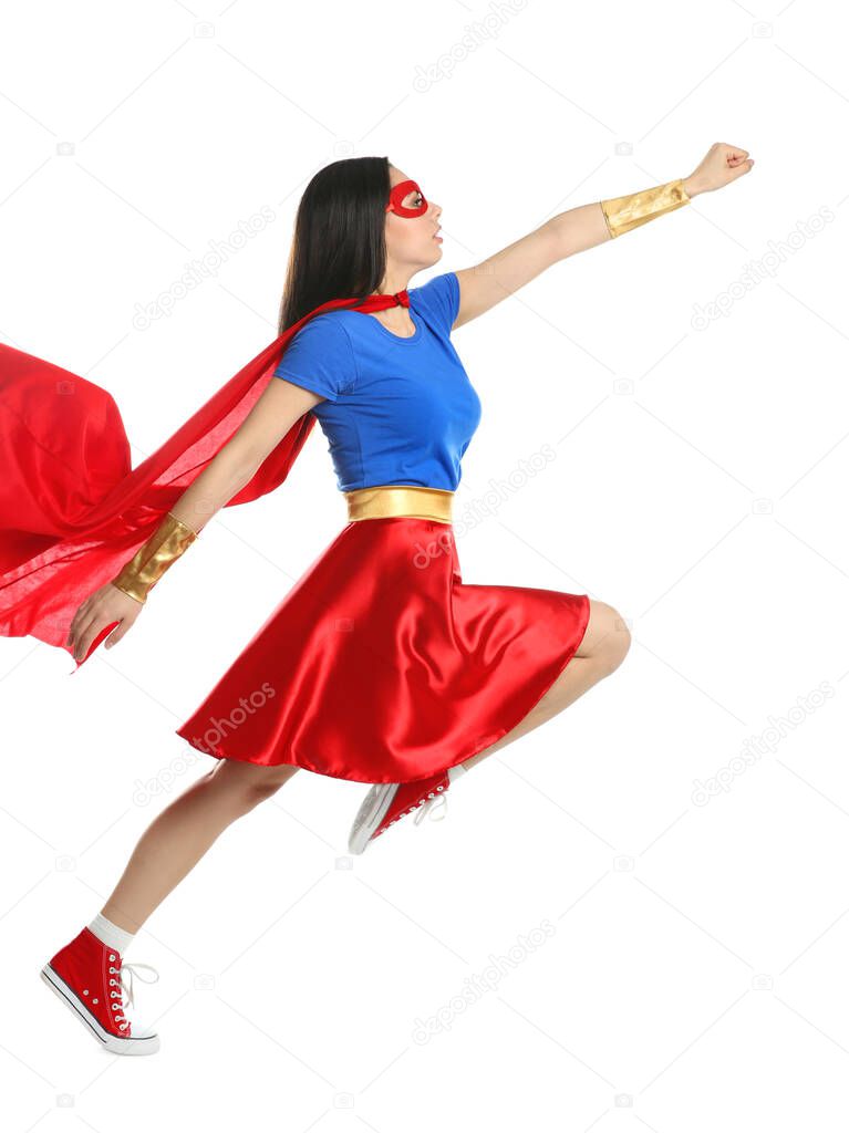 Confident young woman wearing superhero costume on white background