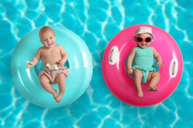 Yüzme havuzunda şişme halkaları olan şirin küçük bebekler.