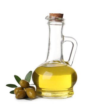 Bir sürahi yağ, olgun zeytin ve beyaz arka planda yapraklar.