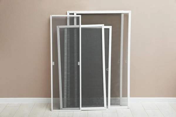 Set of window screens near beige wall indoors