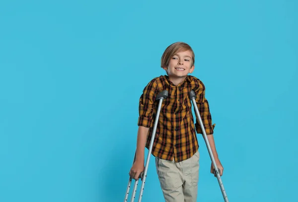 Retrato Niño Feliz Con Muletas Sobre Fondo Azul Claro Espacio —  Fotos de Stock