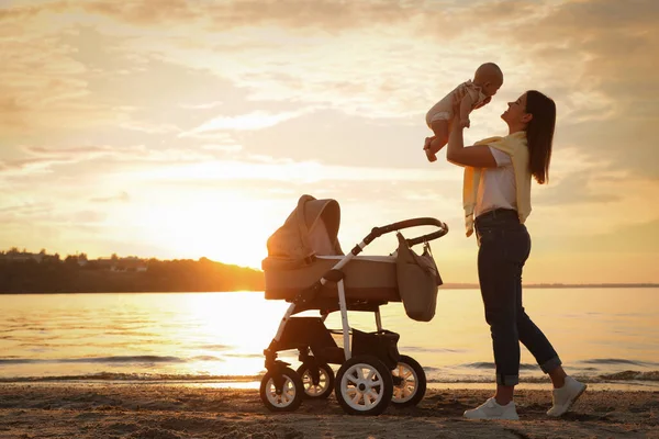 Gelukkig Moeder Met Baby Buurt Van Rivier Bij Zonsondergang — Stockfoto