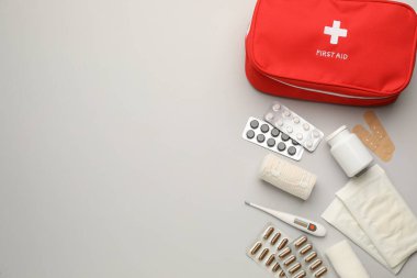 Açık gri arkaplan üzerine ilk yardım çantasıyla düz konum, metin için boşluk