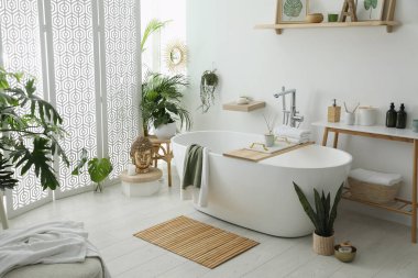 Modern küvetin, ev bitkilerinin ve güzel dekorun olduğu şık bir banyo. Ev tasarımı