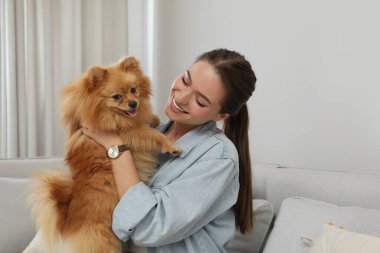 Evinde sevimli köpeği olan mutlu genç bir kadın.
