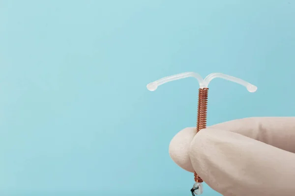 Doctor Sosteniendo Dispositivo Anticonceptivo Intrauterino Forma Sobre Fondo Azul Claro — Foto de Stock