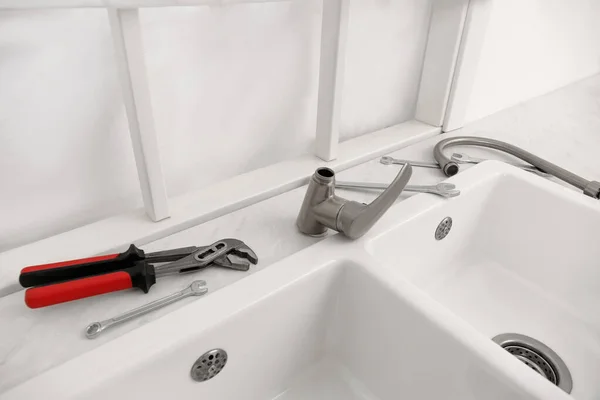 水管工的工具及水龙头 可在厨房台面的水槽附近安装 — 图库照片