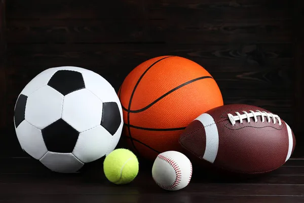 木製のテーブルの上に異なるスポーツボールのセット — ストック写真