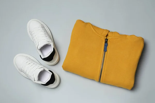 灰色背景的黄色服装和运动鞋 — 图库照片