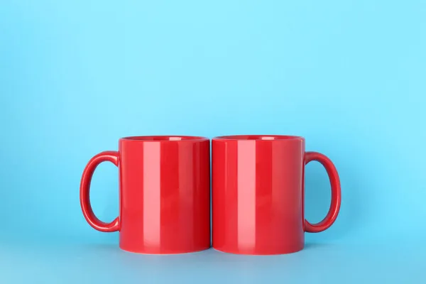 Puste Czerwone Kubki Ceramiczne Jasnoniebieskim Tle — Zdjęcie stockowe