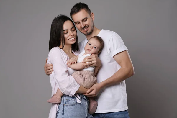 Família Feliz Casal Com Seu Bebê Bonito Fundo Cinza — Fotografia de Stock