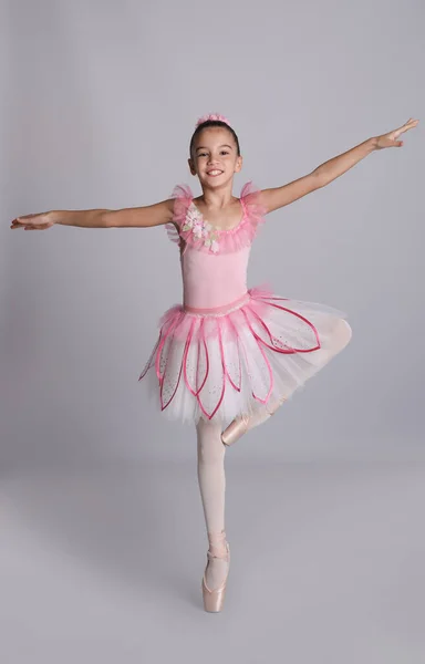Красиво Одетая Маленькая Балерина Танцует Сером Фоне — стоковое фото
