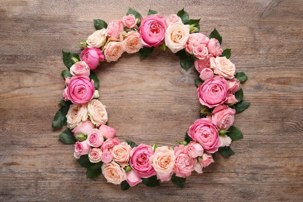 Στεφάνι Από Όμορφα Λουλούδια Τριαντάφυλλου Και Πράσινα Φύλλα Ξύλινο Φόντο — Φωτογραφία Αρχείου