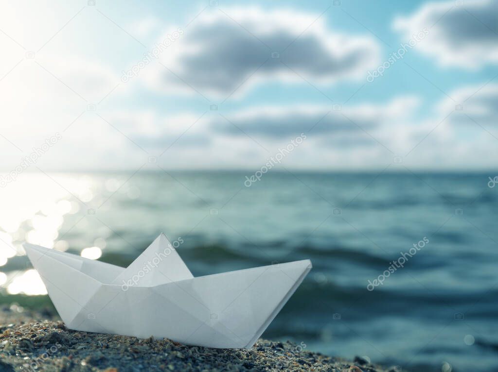 White paper boat near river on sunny day 