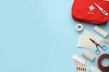 Açık mavi arkaplan üzerine ilk yardım çantasıyla düz konum, metin için boşluk