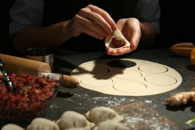 Gri masada gyoza yapan kadın, yakın plan.