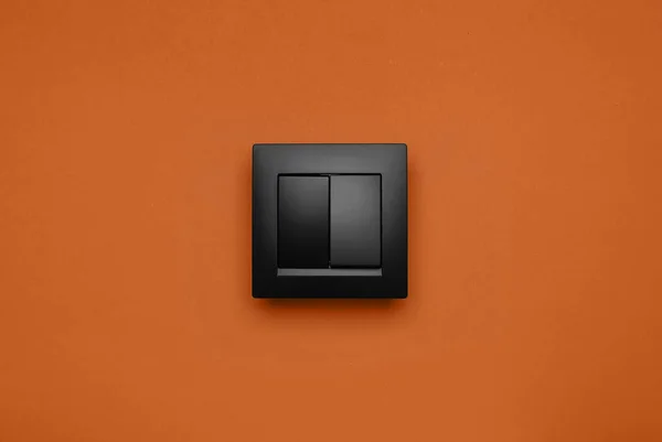 Black Plastic Light Switch Orange Background — Stock Photo, Image