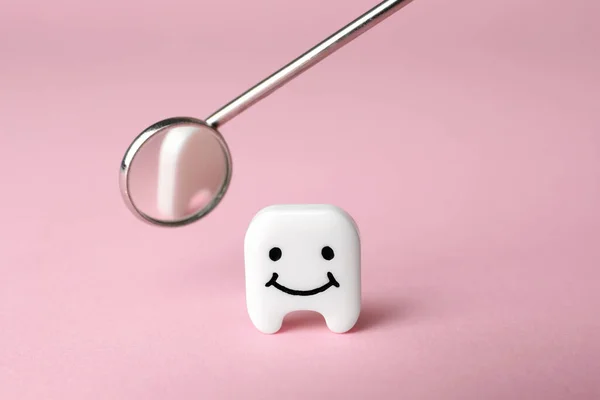 Декоративний Зуб Смішним Обличчям Дзеркалом Стоматолога Рожевому Фоні Крупним Планом — стокове фото