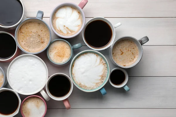 Många Olika Koppar Med Aromatiskt Varmt Kaffe Vitt Träbord Platt — Stockfoto