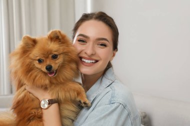 Evinde sevimli köpeği olan mutlu genç bir kadın.