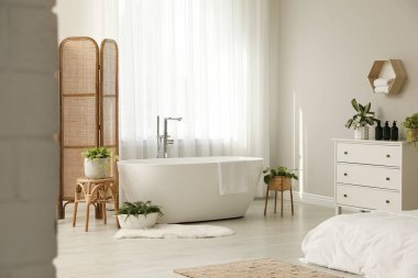 Işık odasının penceresinin yanındaki beyaz küvet. İç tasarım