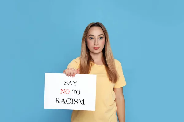 Jovem Segurando Sinal Com Frase Diga Não Racismo Fundo Azul — Fotografia de Stock