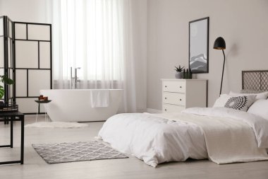 Beyaz küvetli ve yataklı şık bir daire.