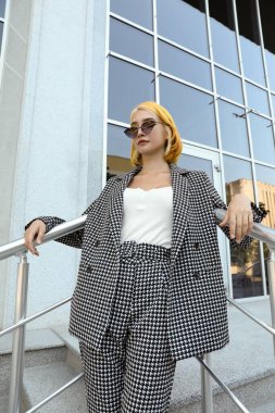 Açık havada güneş gözlüklü parlak saçlı güzel bir genç kadın.