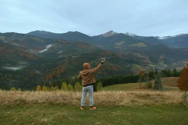 山の中に現代の無人機を持つ若い男 バックビュー — ストック写真