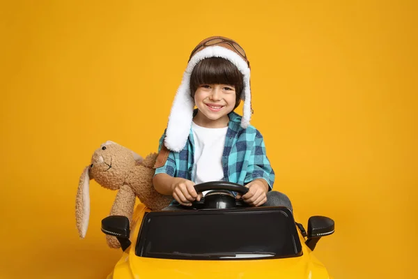 Menino Bonito Com Coelho Brinquedo Dirigindo Carro Infantil Fundo Amarelo — Fotografia de Stock