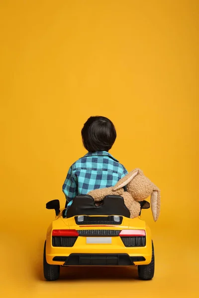 Cute Little Boy Toy Bunny Driving Children Car Yellow Background — Stock Photo, Image