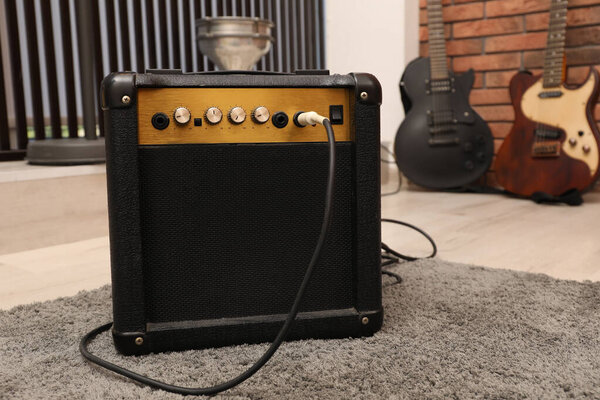 Modern guitar amplifier on floor in studio