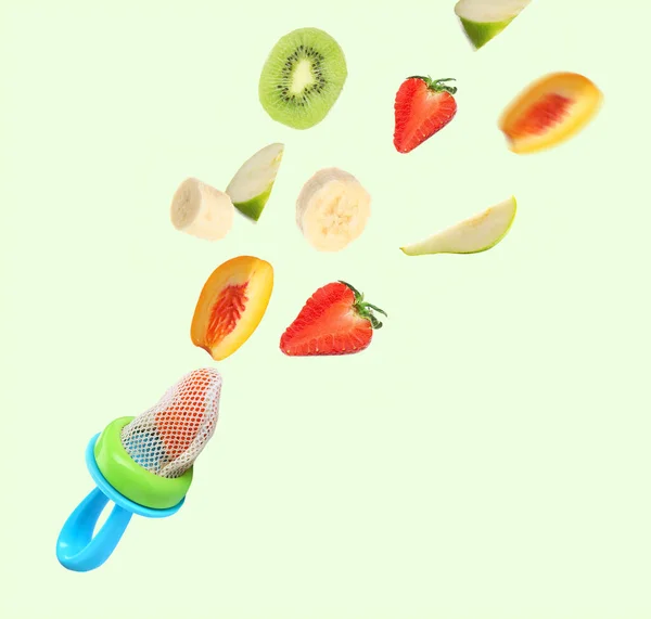 Nibbler Frutas Diferentes Caindo Sobre Fundo Claro Alimentador Bebés — Fotografia de Stock