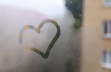Sisli pencereye kalp çizilmiş. Yağmurlu hava