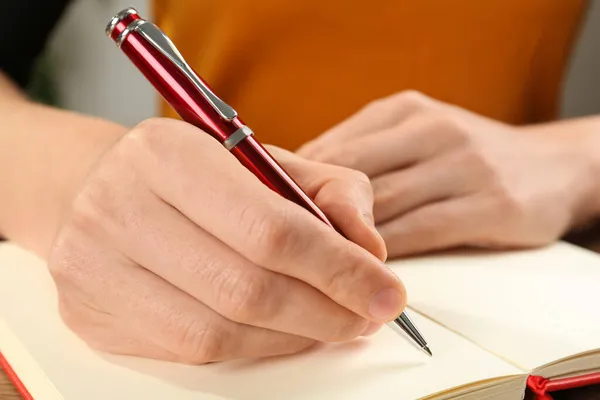 Γυναίκα Γραφή Στυλό Στο Σημειωματάριο Στο Τραπέζι Closeup Των Χεριών — Φωτογραφία Αρχείου