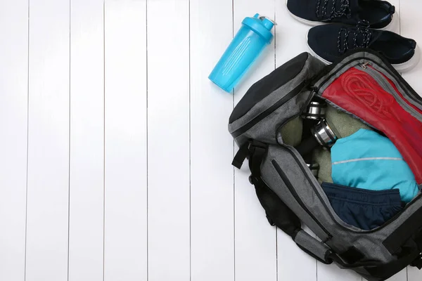 白い木製の背景にジムバッグやスポーツ用品 フラットレイアウト テキストのスペース — ストック写真