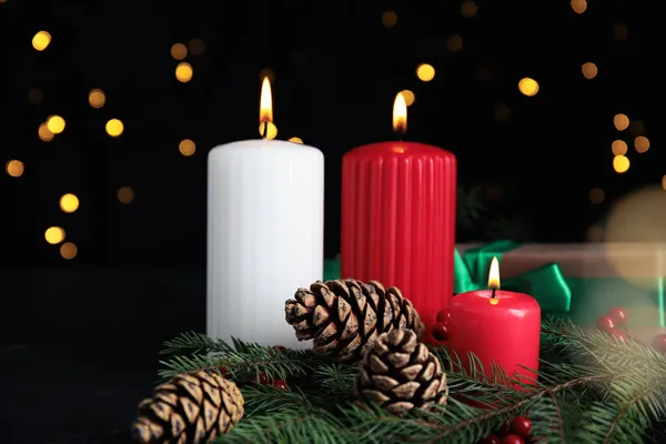Égő Gyertyák Ajándékdobozok Fenyőágak Tölcsérek Sötét Asztalon Homályos Karácsonyi Fények — Stock Fotó