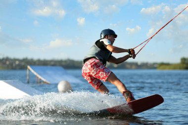 Genç çocuk nehirde wakeboard yapıyor. Aşırı su sporu