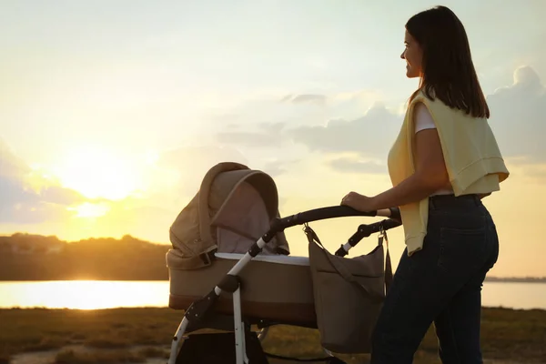 Madre Feliz Con Bebé Cochecito Caminando Cerca Del Río Atardecer — Foto de Stock