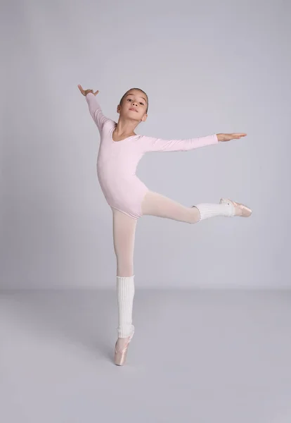 Маленькая Балерина Практикует Танцевальные Движения Сером Фоне — стоковое фото