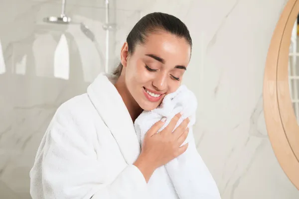 バスルームでタオルで顔を拭く美しい若い女性 — ストック写真